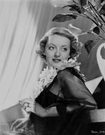 Bette Davis - Bette Davis Portrait Lying Back on a Table in Sunflower Garland and Black Linen Lace Long Sleeves