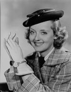 Bette Davis - Bette Davis Portrait smiling in Black Flat Hat in Checkered Suit and White Collar Shirt with Tie