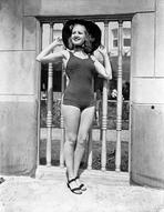 Betty Grable - Betty Grable Posed with Hands on the Hat in Black Round Hat and One Piece Swimsuit with Black Flats
